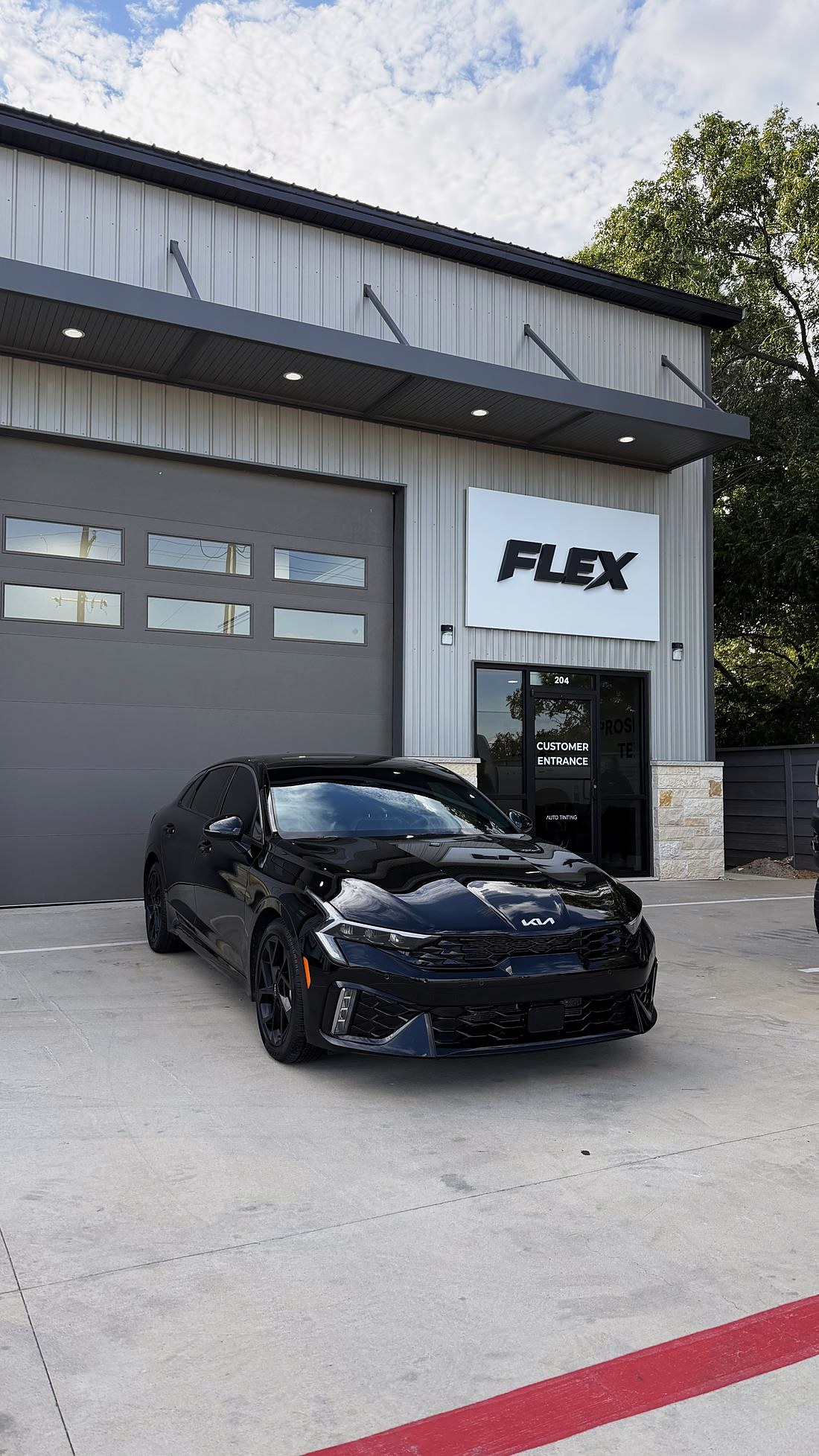 Customer entrance, Unit 204, at FLEX Auto Styling with a black Kia parked outside